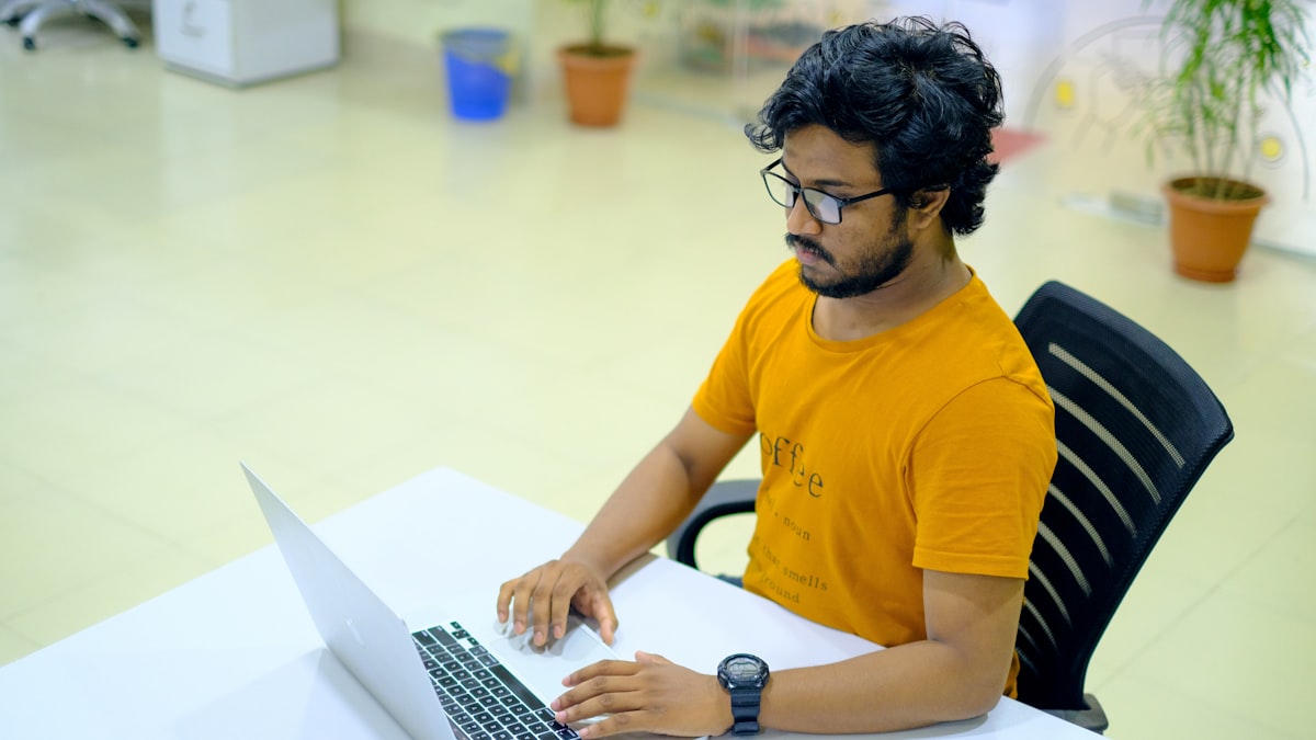 Indian young man at MacBook in office &mdash; checking Udyam registration status