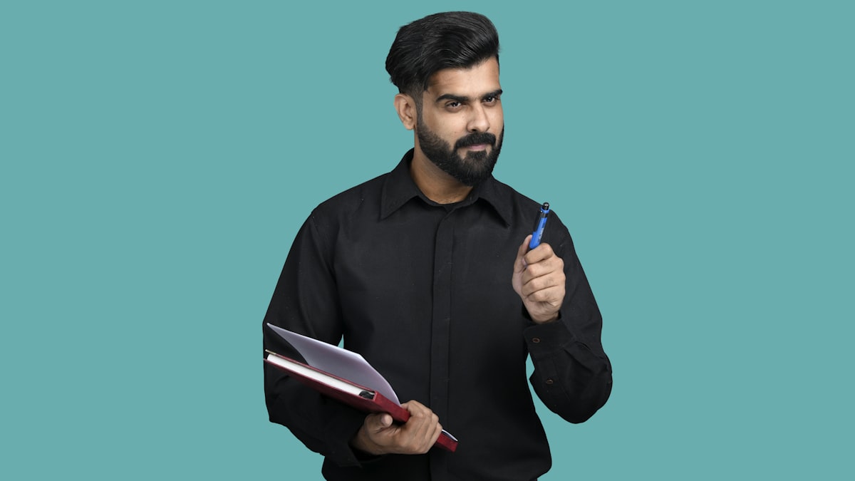 Indian professional holding a folder and pen &mdash; document validation in progress