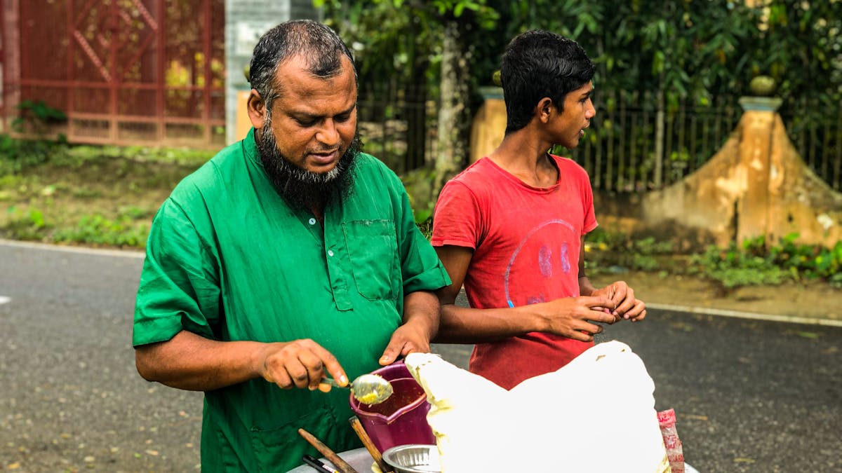 Indian father and son working together at a street food cart — family business