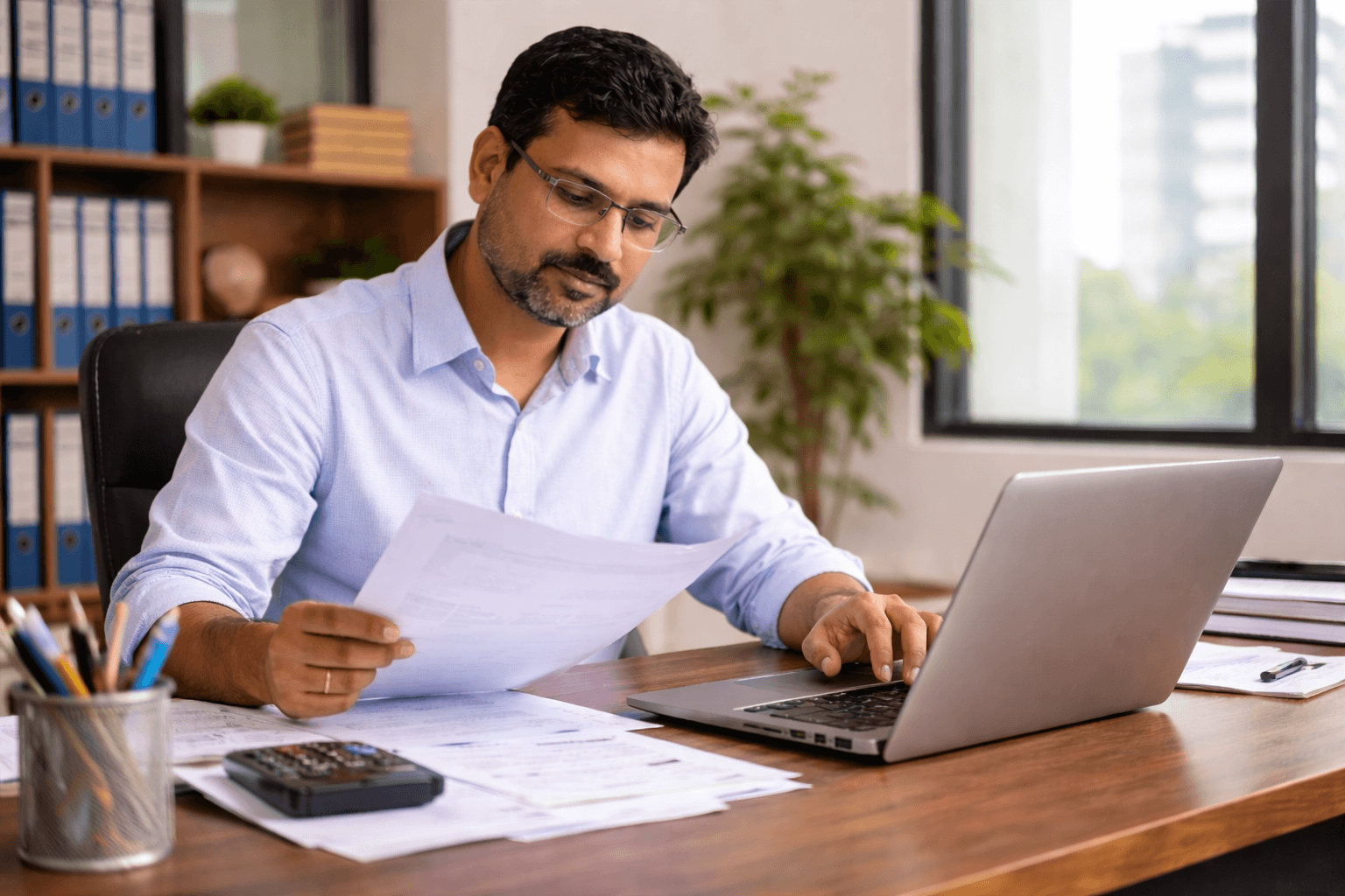 Business owner verifying Udyam registration Indian business owner verifying Udyam registration while checking documents on laptop